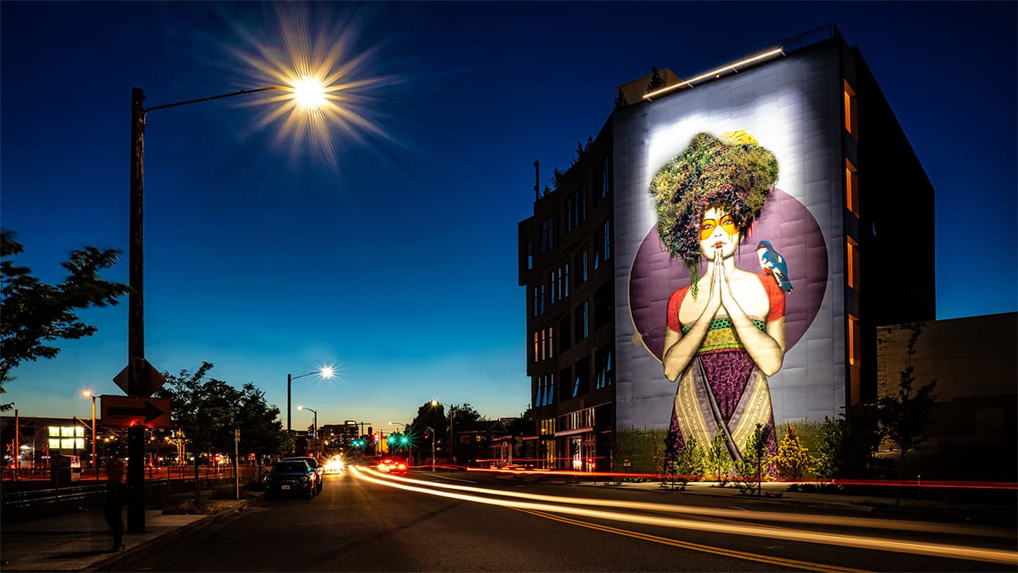The SolTerra Building on SE Division, Portland, at dusk with its mural lit up